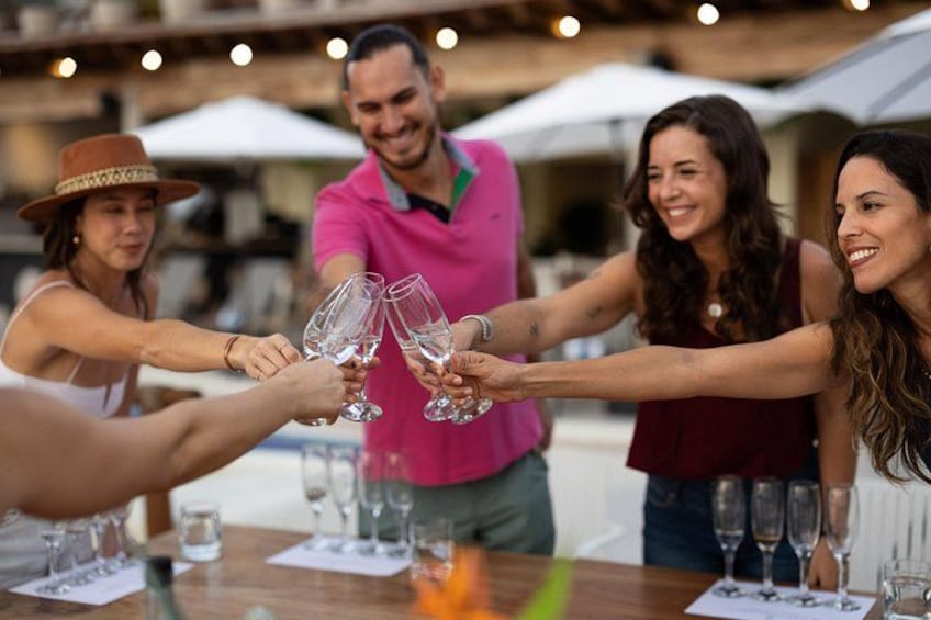 Un grupo de personas brindando con copas de champán en un restaurante al aire libre. 1