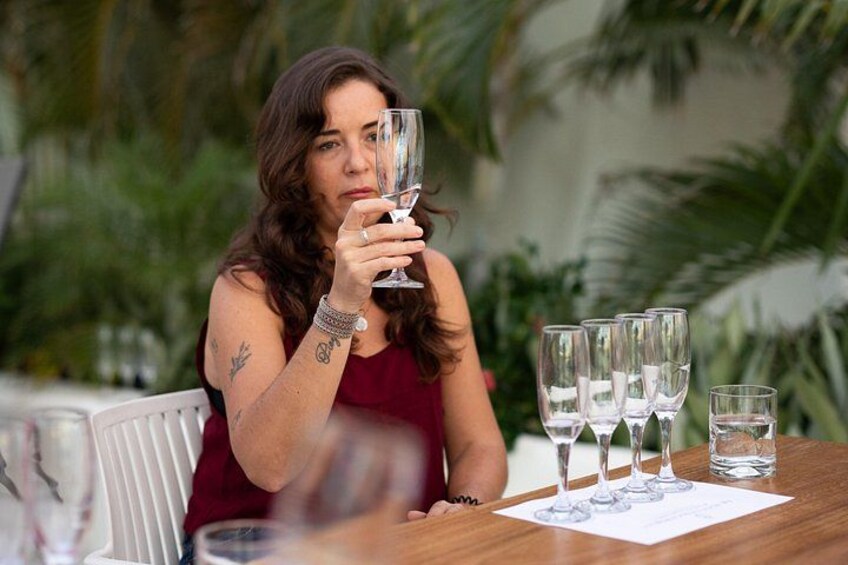 Une personne assise à une table devant plusieurs verres à vin et un verre d’eau. 3