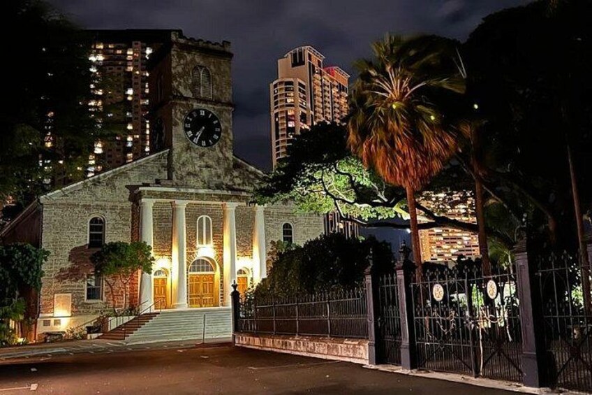 A historic building with a clock tower, surrounded by palm trees and modern high-rise buildings. 4