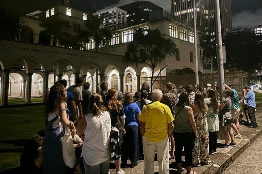 A group of people gathered outdoors, standing in a line, with a building in the background. 5