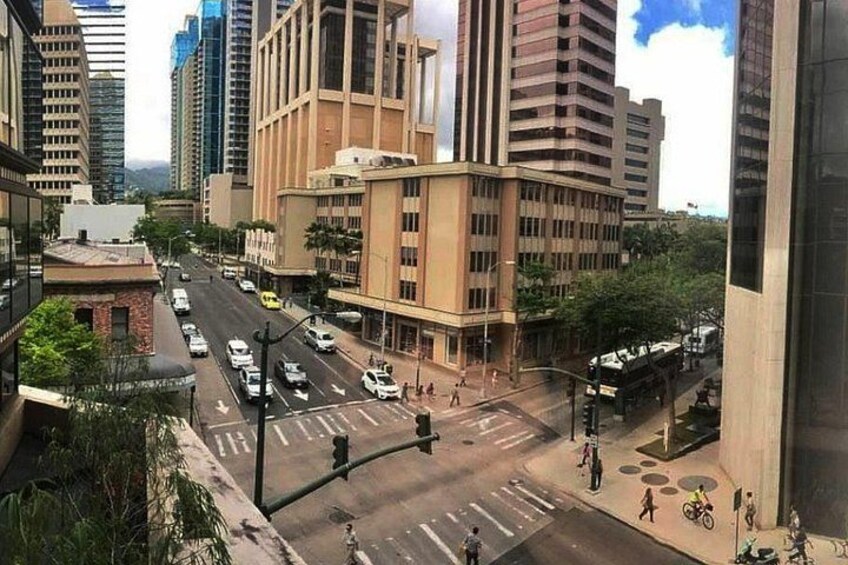 A busy urban street with tall buildings, a crosswalk, and vehicles. 2