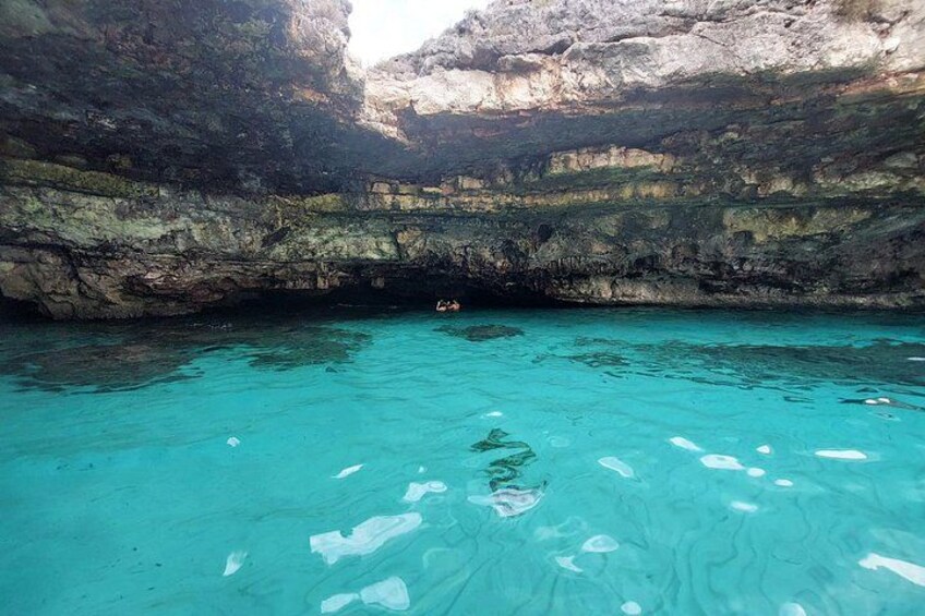 Una masa de agua azul cristalina rodeada de acantilados rocosos. 1