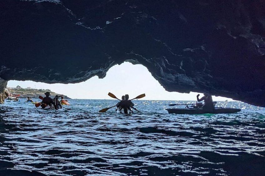 Kayakisti che si muovono attraverso un'imponente formazione rocciosa a forma di arco. 2