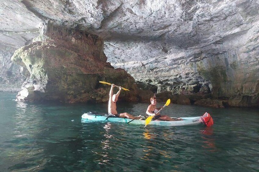 Due persone che fanno kayak in una grotta con acqua e pareti rocciose. 5