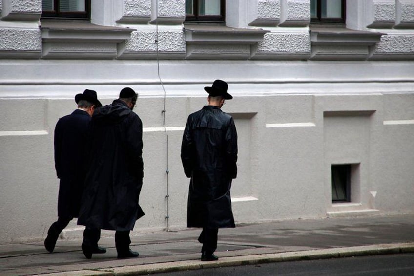 Three people walking on a sidewalk. 5