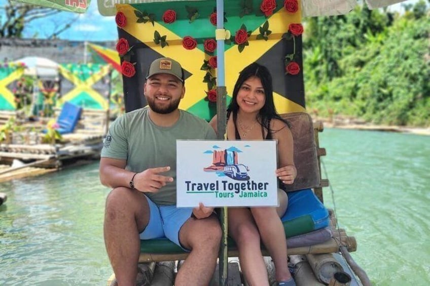 Due persone su una barca con un cartello che riporta 'Travel Together Tours Jamaica'. 2