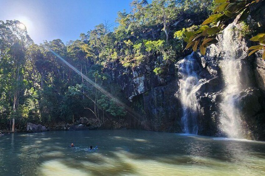 A waterfall, a body of water, and a forested area. 3