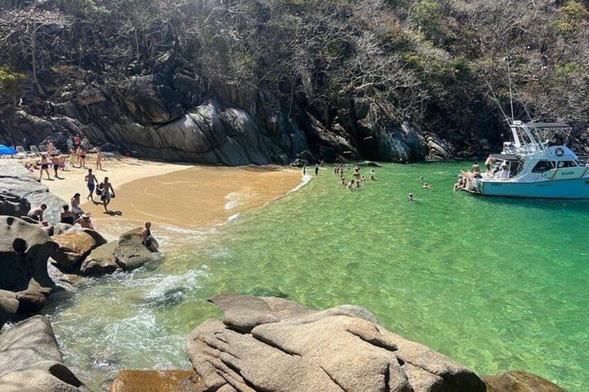 Une plage avec une eau claire, des rochers et un bateau. 5