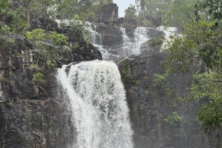 A waterfall cascading over rocky terrain surrounded by greenery. 4