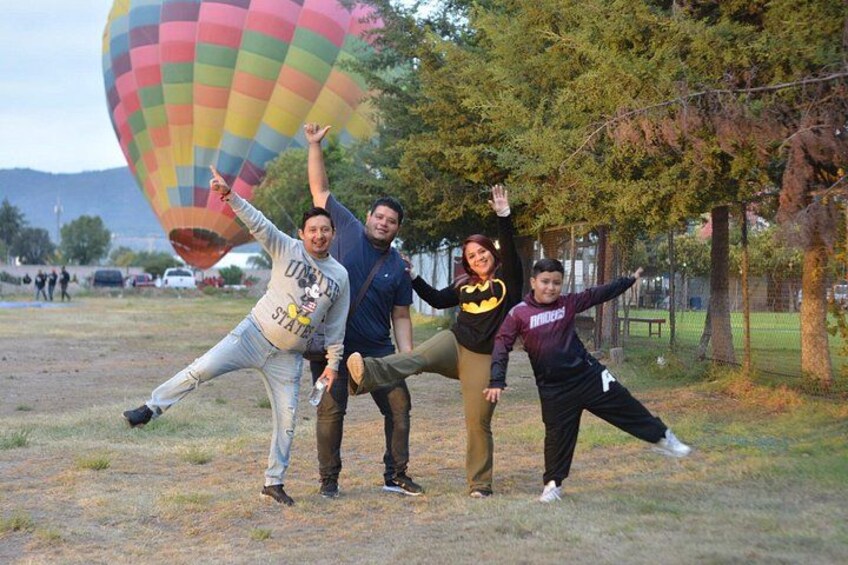 Een groep mensen staat te poseren, met een luchtballon op de achtergrond. 5