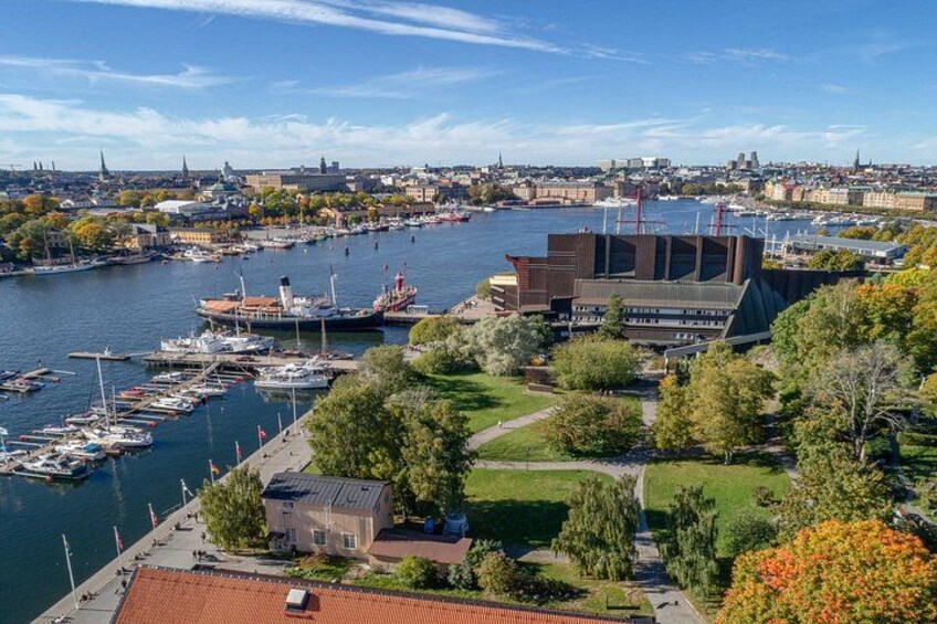 A harbor with boats, a large building, and a cityscape in the background. 2
