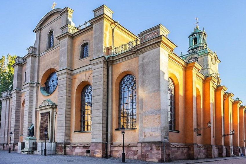 A historic building with arched windows, a clock, and a bell tower. 3
