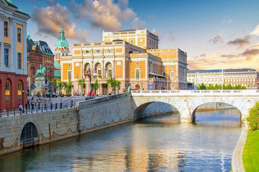 A river with a stone bridge, historic buildings, and a statue. 5