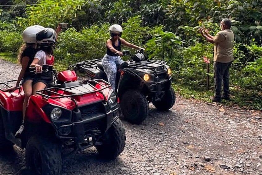 People riding ATVs on a dirt path surrounded by greenery. 4