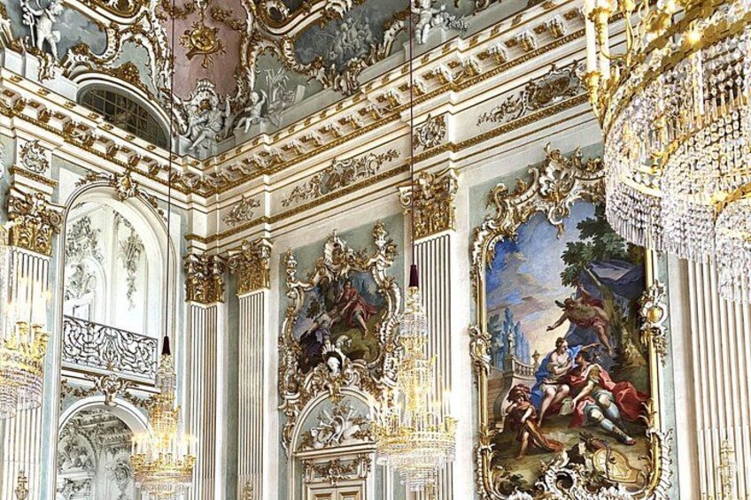 An ornate room with elaborate frescoes and gilded decorations. 1