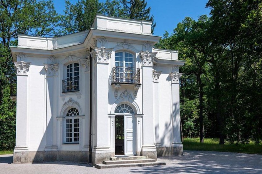 Un edificio neoclassico bianco con colonne decorate e un balcone. 5