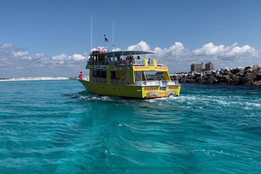 Un barco amarillo llamado 'Hannah Marie' en aguas turquesas, con una costa rocosa al fondo. 2