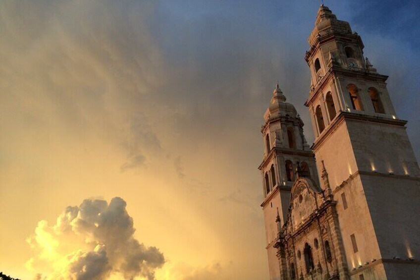 A church with two bell towers and a large cloud in the sky. 1