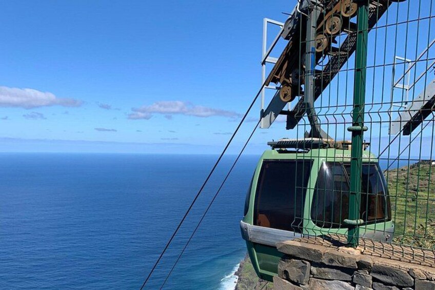 A cable car with a clear view of the ocean and a rocky shoreline. 2