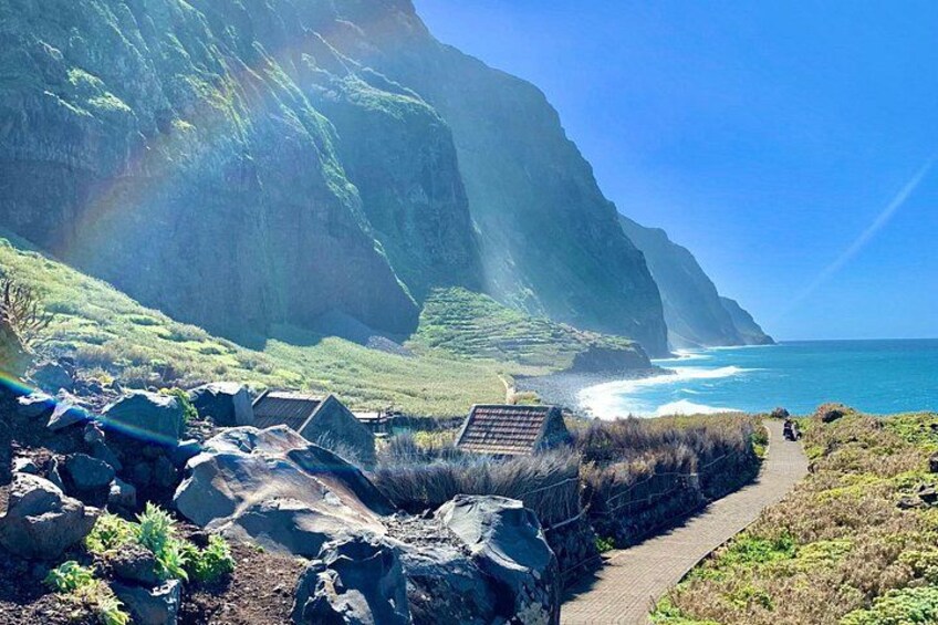A coastal landscape with a rocky path, cliffs, and the ocean. 1