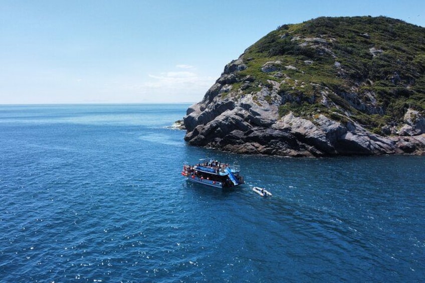 A boat on a calm sea near a rocky island. 4