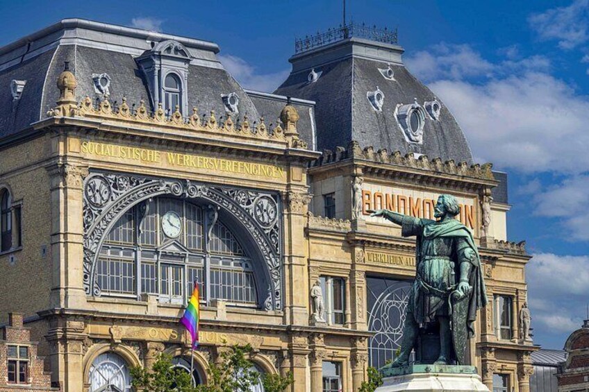 A historic building with ornate architecture, a large arched window, and a statue. 3