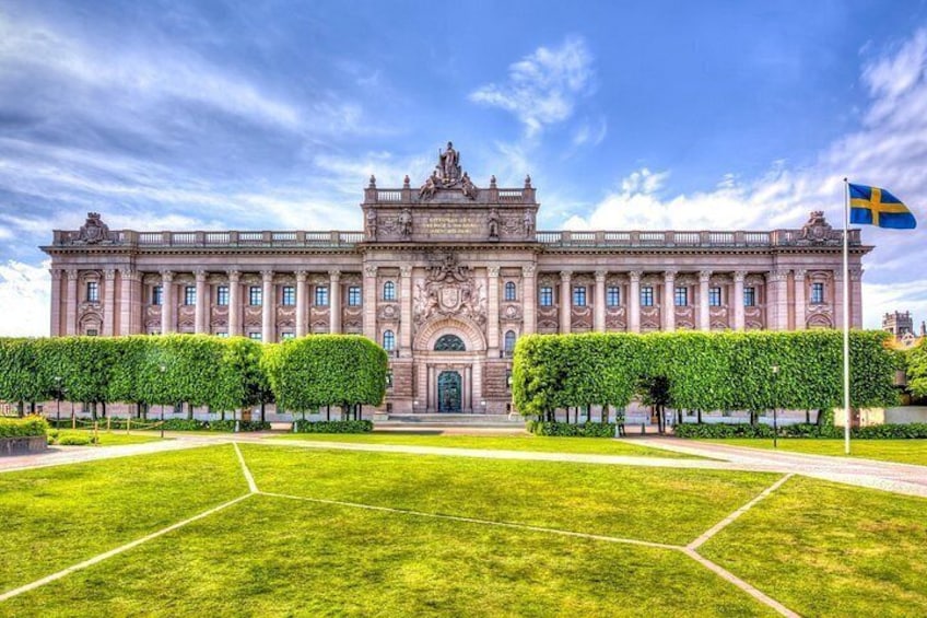 Un edificio grande e histórico con fachada simétrica, entrada central y bandera sueca. 4