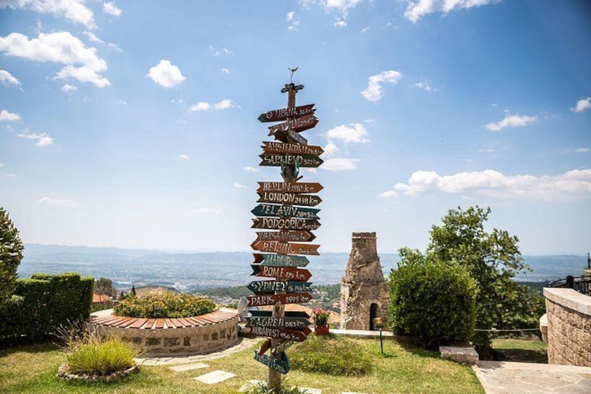 A signpost with multiple directional arrows pointing to various cities and distances. 3