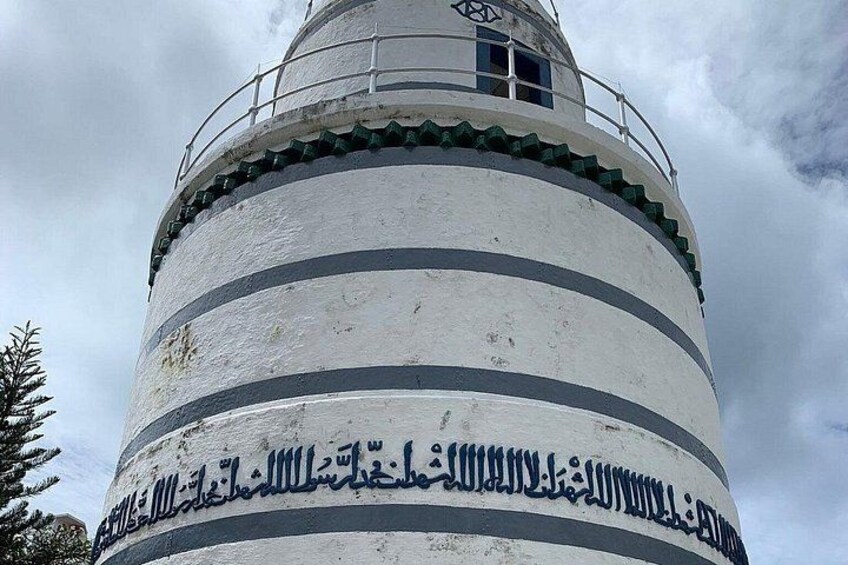 Een vuurtoren met horizontale strepen en Arabische inscripties. 4
