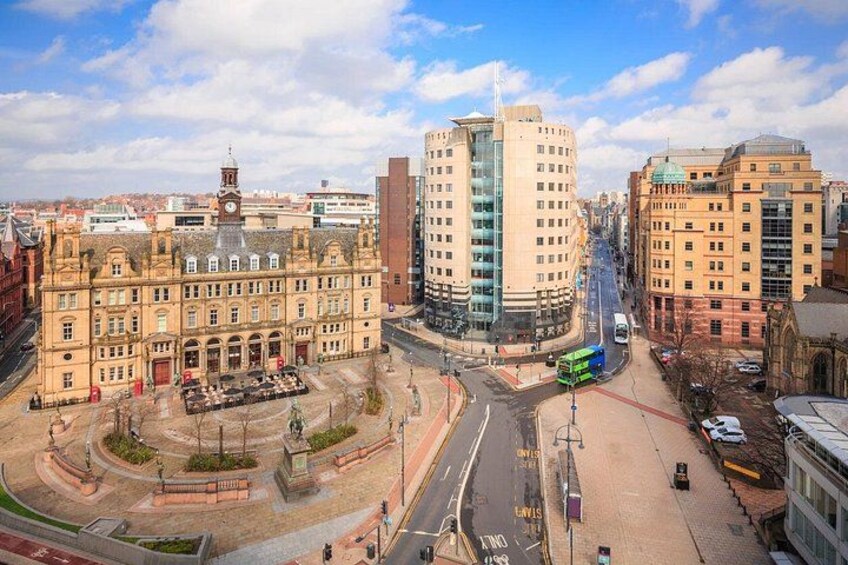 A cityscape with historic buildings, a roundabout, and modern high-rises. 4