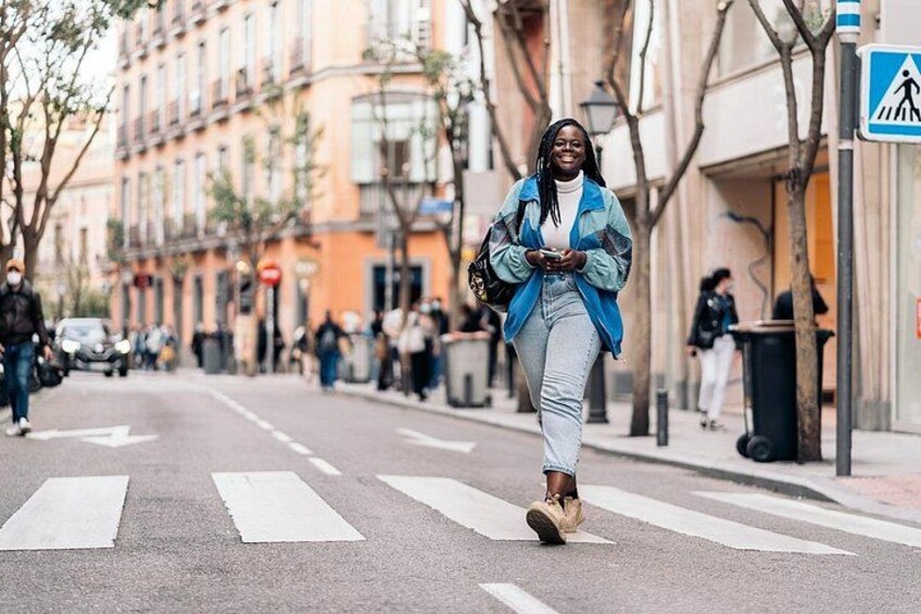 A person crossing a street with a pedestrian crossing sign in the background. 5