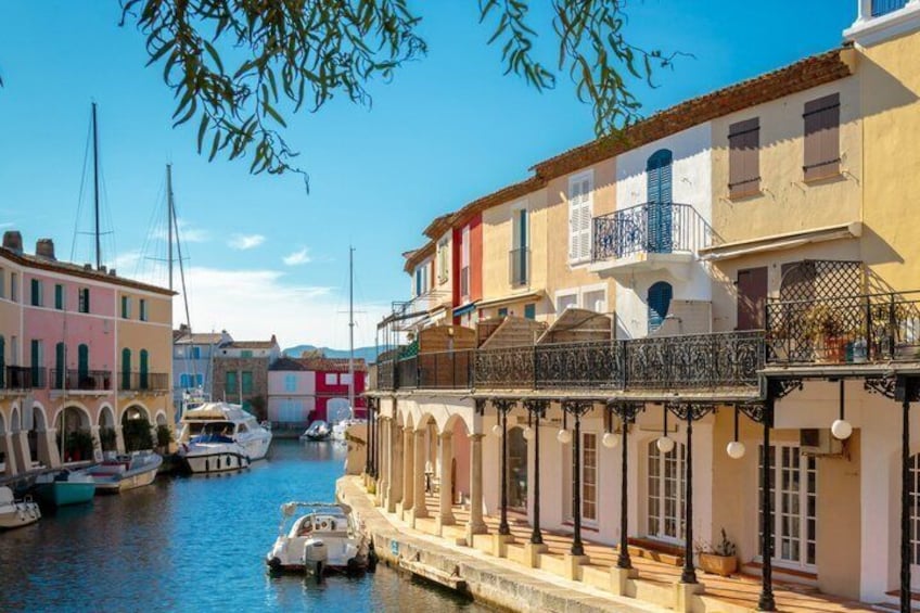 A canal with boats, colorful buildings, and a clear sky. 4