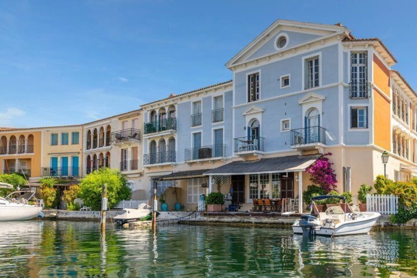 A waterfront property with a large building, boats, and a clear sky. 3