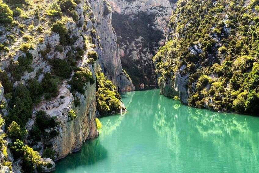 A canyon with turquoise water and rocky cliffs. 1