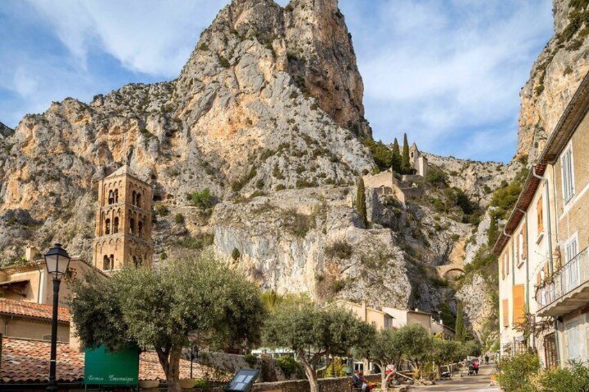 A mountainous landscape with a bell tower, buildings, and a narrow street. 3