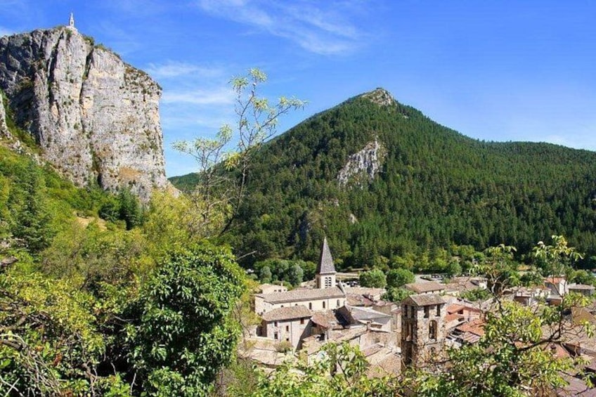 A village nestled in a valley with a prominent rocky mountain in the background. 5