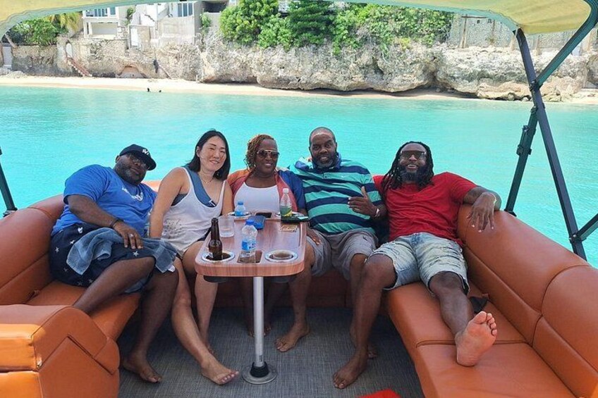 Un grupo de personas en un bote cerca de una playa con agua azul cristalina. 3