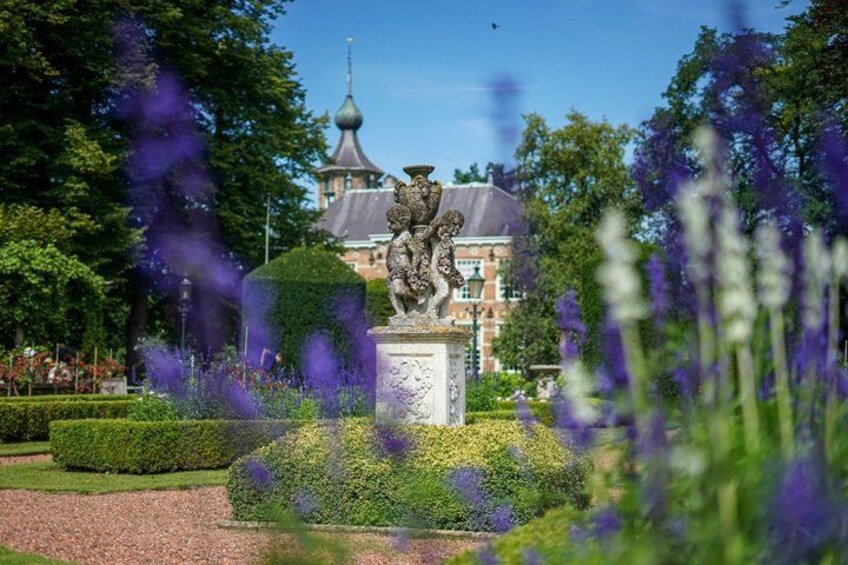 Une statue dans un jardin, avec un bâtiment en arrière-plan. 2