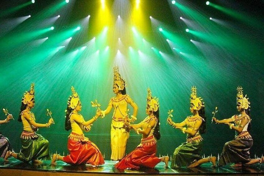 A group of dancers in traditional costumes performing on a stage with bright stage lighting. 1