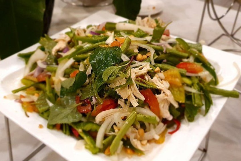A plate of mixed salad with various vegetables and nuts. 5