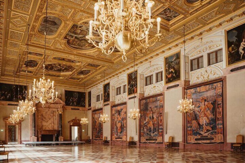 En storslagen hall med utsmyckade kristallkronor, detaljerade väggmålningar och ett marmorgolv. 1