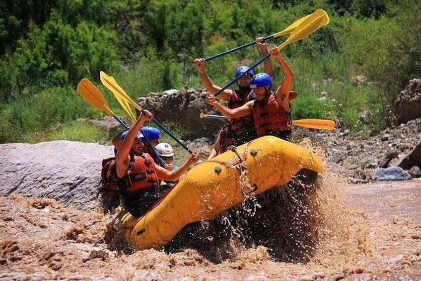Un grupo de personas en un bote amarillo navegando por un río embarrado. 2