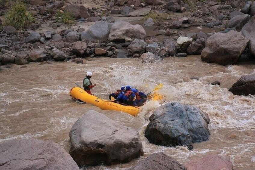 Un río con rocas y una balsa amarilla con gente. 5