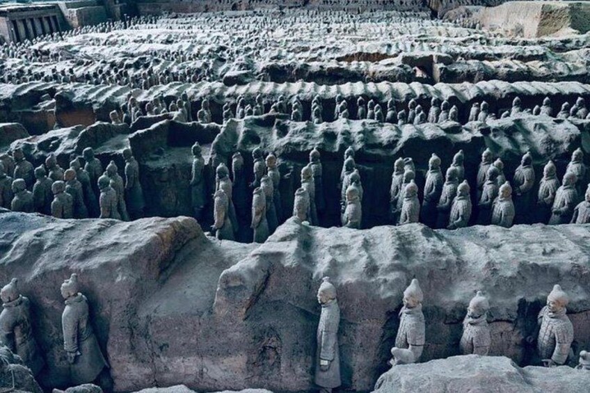 Terracotta soldiers arranged in rows, standing in formation. 4