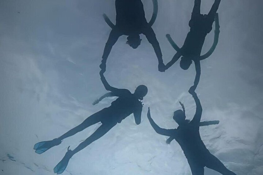 Silhouettes of people in a circular formation, possibly engaged in a group activity or exercise. 4