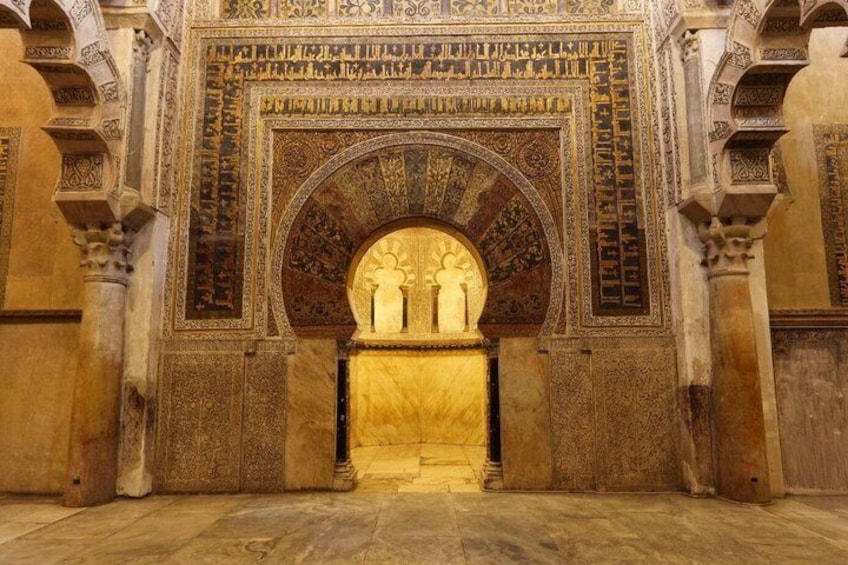 Un arco ornamentado con diseños intrincados y un nicho central. 3