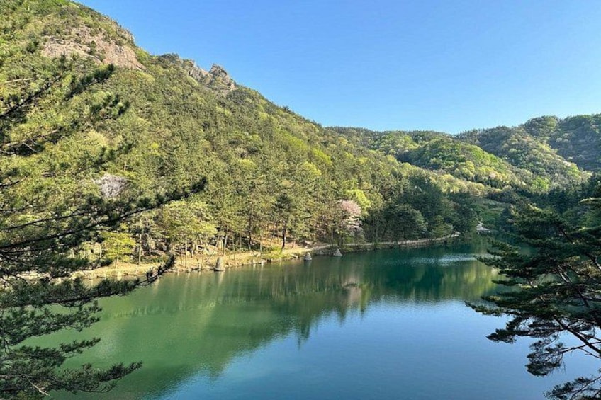 A calm lake surrounded by lush green hills and trees. 3