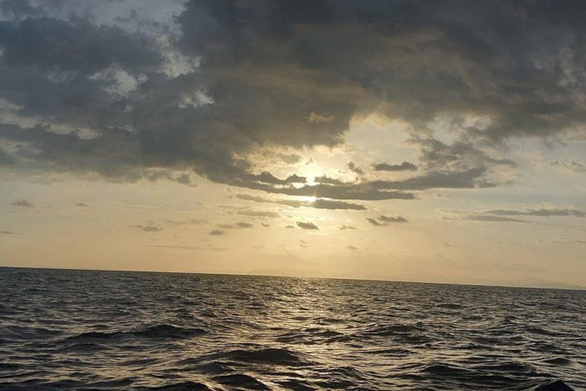 A sunset over a body of water with clouds in the sky. 2