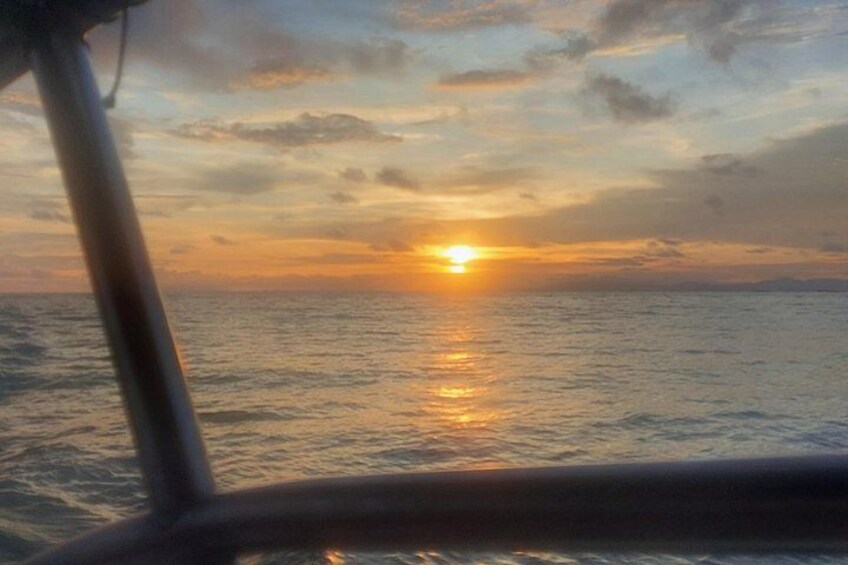 A sunset over the ocean with a boat in the foreground. 2