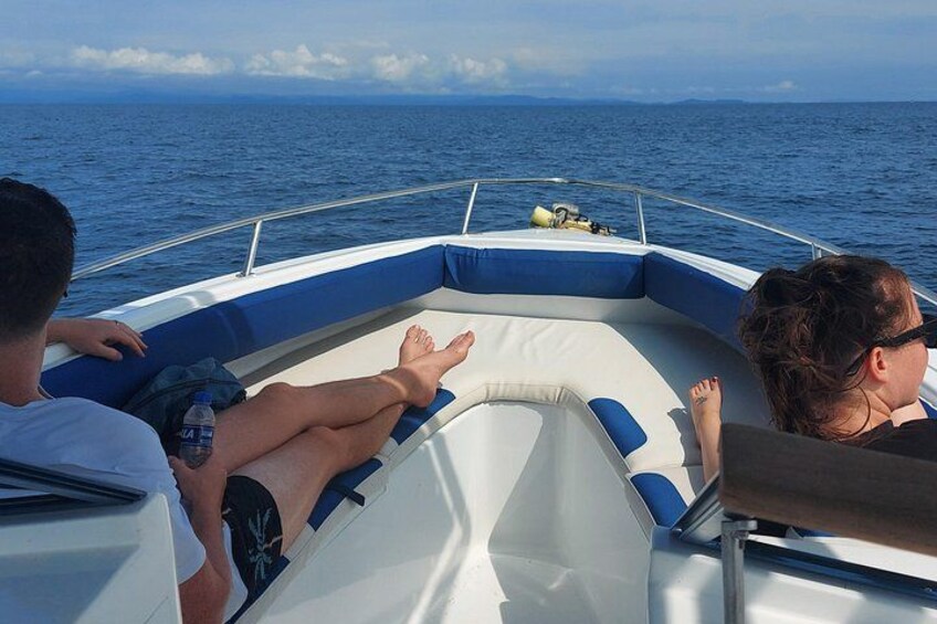 Un bateau sur lequel se trouvent deux personnes allongées sur le pont, face à la mer. 3